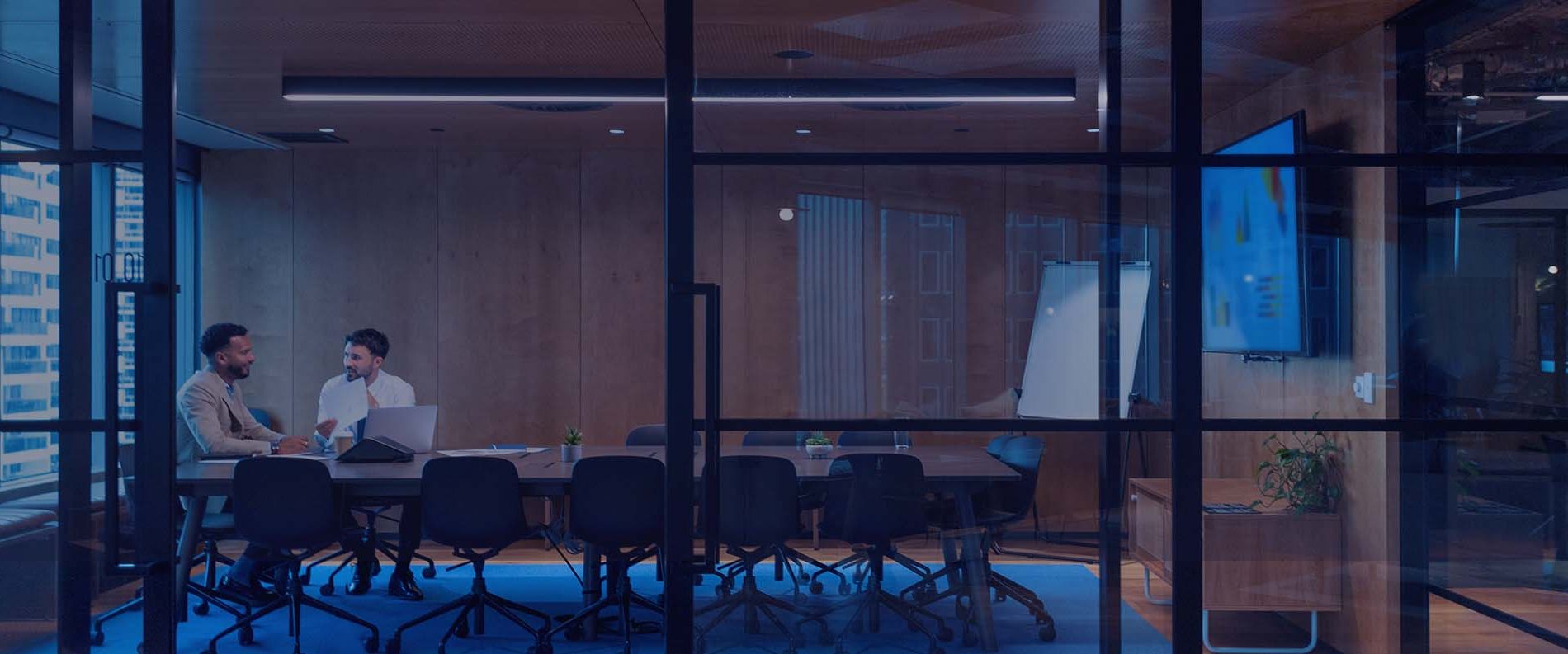 חדר ישיבות עם אנשים יושבים סביב שולחן, עוסקים בדיון, המייצגים את 'קפיטל ניהול הון'